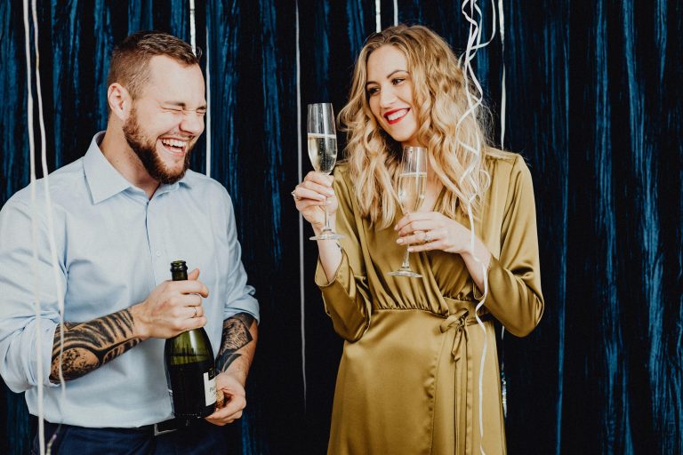 A happy couple enjoying a festive party, toasting with champagne.